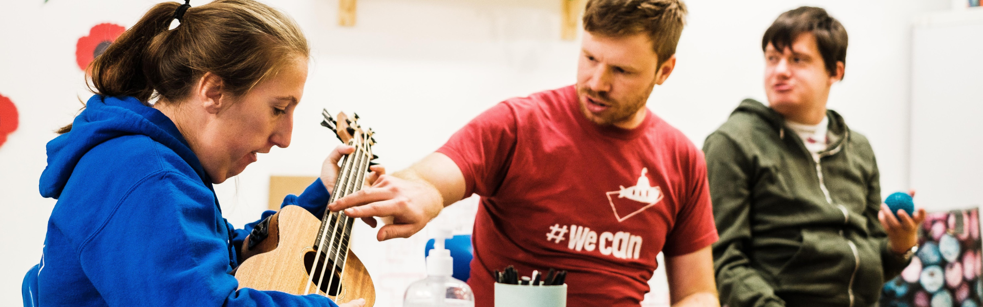 Staff showing member how to play a ukulele